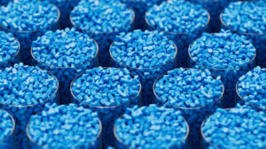 Grid of glasses filled with blue plastic polypropylene granules, masterbatch polymer grain, with shallow DOF. HDPE or PVC resin pellets. 3d render illustration